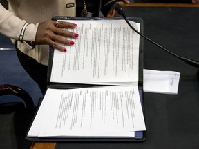 An aide to Facebook CEO Mark Zuckerberg closes a binder of notes left on the table as Zuckerberg takes a short break from testifying before a joint hearing of the Commerce and Judiciary Committees on Capitol Hill in Washington, Tuesday, April 10, 2018, about the use of Facebook data to target American voters in the 2016 election.