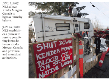 A protester stands on top of a trailer outside the main gates of Kinder Morgan in Burnaby.
