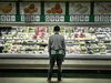 A T&T Supermarket employee looks over the fresh produce section at a story in Markham, Ont.