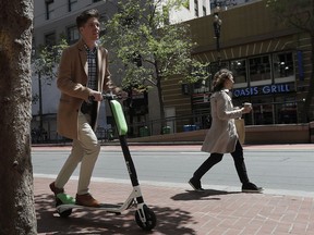 Jack Handlery rides a motorized scooter in San Francisco, Tuesday, April 17, 2018. San Francisco is ordering three companies that rent out motorized scooters to stop operating until they can ensure riders are following state law and the dockless devices are not a hazard to the public.