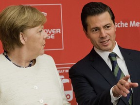 German chancellor Angela Merkel, left, and Mexico's President  Enrique Pena Nieto, arrive for the opening of the Hannover Fair, in Hannover, Germany, Sunday, April 22, 2018.
