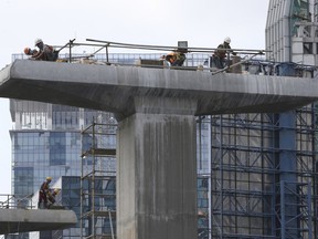 Indonesian laborers work at Light Rail Transit (LRT) construction site in Jakarta, Indonesia, Friday, April 13, 2018. Moody's upgraded Indonesia's credit rating on Friday due to increased confidence the government will maintain its recent track record of responsibly managing the national budget and interest rate policy.