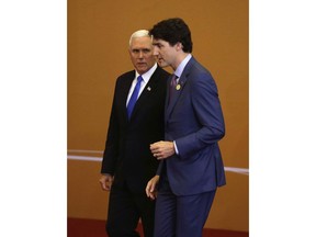 U.S. Vice President Mike Pence, left, talks with Canada's Prime Minister Justin Trudeau as they arrive for the group photo at Americas Summit in Lima, Peru, Saturday, April 14, 2018.