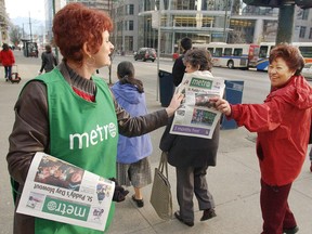 A vendor hands out the Metro in Vancouver.