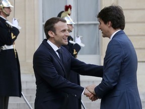 French President Emmanuel Macron, left, welcomes Canadian Prime Minister Justin Trudeau on the occasion of their meeting at the Elysee Palace in Paris, Monday, April 16, 2018. Trudeau is in France for a two-day visit.