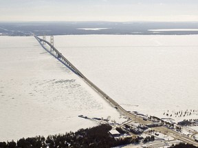 FILE - This Feb. 11, 2014 aerial file photo shows a view of the Mackinac Bridge, which spans a 5-mile-wide freshwater channel called the Straits of Mackinac that separates Michigan's upper and lower peninsulas. Officials say hundreds of gallons of potentially toxic coolant fluid have leaked from electric power cables in the waterway that links Lake Huron and Lake Michigan.