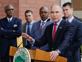 FILE - In this April 19, 2017, file photo, Environmental Protection Agency Administrator Scott Pruitt speaks at a news conference with Pasquale "Nino" Perrotta, second from left, in East Chicago, Ind. Perrotta, the security chief for the head of the Environmental Protection Agency worked on the side as a private investigator for the owner of a tabloid news company with close ties to President Donald Trump.