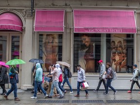 FILE- In this April 4, 2018, file photo, shoppers walk past the Victoria's Secret store on Broadway in the Soho neighborhood of New York. On Monday, April 30, the Commerce Department issues its March report on consumer spending.