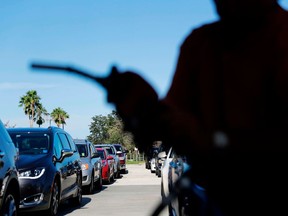 FILE- In this Sept. 13, 2017, file photo, cars wait in line for gas as a station in Miromar Lakes, Fla. Environmental regulators announced on Monday, April 2, 2018, they will ease emissions standards for cars and trucks, saying that a timeline put in place by President Obama was not appropriate and set standards "too high."