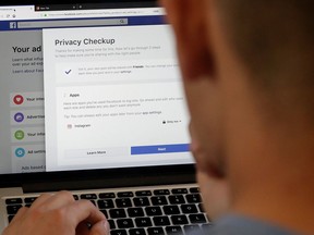 FILE - In this March 26, 2018, file photo, a man poses for photos in front of a computer showing Facebook ad preferences pages in San Francisco. Lost amid a flurry of Facebook announcements about privacy settings and data access is a much more fundamental question. Is Facebook really changing its relationship with its users, or just tinkering around the edge of a deeper problem...its insatiable appetite for the data it uses to sell ads?