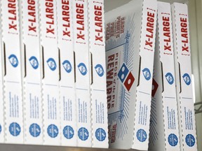 FILE- This Oct. 27, 2016, photo shows Domino's Pizza boxes at one their locations, in Hialeah, Fla. The pizza chain said Monday, April 16, 2018, that its drivers can meet customers at beaches, parks and landmarks to hand over pizza, cheesy bread or chicken wings. In all, Domino's said it can deliver to 150,000 outdoor locations in the United States, including under the Gateway Arch in St. Louis, or the beaches of Siesta Key, Fla.