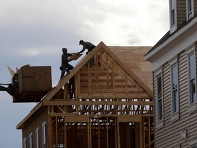 FILE- In this Feb. 26, 2018, photo, construction workers work on a new townhouse in Wood-Ridge, N.J. On Monday, April 16, the National Association of Home Builders/Wells Fargo releases its March index of builder sentiment.