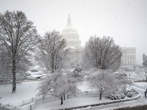 FILE- In this March 21, 2018, file photo, snow falls at the U.S. Capitol in Washington. On Wednesday, April 11, 2018, the Treasury Department releases federal budget data for March.