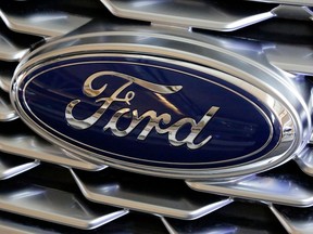 FILE- This Feb. 15, 2018, file photo shows a Ford logo on the grill of a 2018 Ford Explorer on display at the Pittsburgh Auto Show. Ford Motor Co. reports earnings Wednesday, April 25.