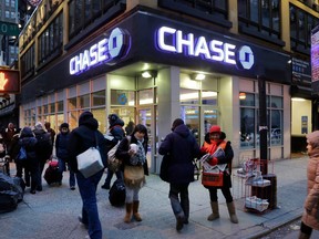 FILE - In this Jan. 14, 2015, file photo, people walk past a branch of Chase bank, in New York. JPMorgan Chase & Co. reports earnings Friday, April 13, 2018.
