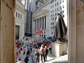 FILE- In this April 5, 2018, file photo, a statue of George Washington, on the steps Federal Hall, overlooks the New York Stock Exchange. The U.S. stock market opens at 9:30 a.m. EDT on Monday, April 16.