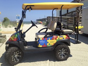 This July 21, 2017 photo shows a Champion Autism Network golf cart decorated with puzzle pieces, a symbol for autism, in Surfside, S.C., with the Surfside Pier in the background. The golf cart is sponsored by area businesses who purchase puzzle pieces and get their logos printed on them. The Champion Autism Network works with local businesses and attractions in the Myrtle Beach area, including venues in Surfside, to make the destination more welcoming to visitors with kids on the autism spectrum by training workers in the hospitality industry to be sensitive to their needs.