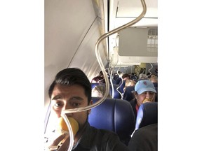 In this April 17, 2018 photo provided by Marty Martinez, Martinez appears with other passengers after a jet engine blew out on the Southwest Airlines Boeing 737 plane he was flying in from New York to Dallas, resulting in the death of a woman who was nearly sucked from a window during the flight with 149 people aboard. A preliminary examination of the blown jet engine that set off a terrifying chain of events showed evidence of "metal fatigue," according to the National Transportation Safety Board.