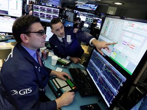 Specialists Robert Tuccillo, left, and Matthew Greiner work at their post on the floor of the New York Stock Exchange, Friday, April 6, 2018. Another increase in trade tensions has stocks reversing course and falling again Friday morning as the U.S. considers an even larger set of tariffs on imports from China.