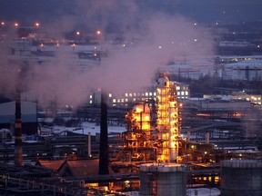 Petroleum cracking towers are seen illuminated by lights at a petroleum refinery in Russia.
