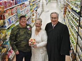 In this April 1, 2018 photo, Larry Spiering and Becky Smith pose for a photo where they held their wedding ceremony officiated by District Judge Frank Pallone on Easter Sunday in aisle 13 of the Community Market in Lower Burrell, Pa. Smith said she was working at the supermarket when Spiering walked up and gave her a piece of paper with his name and phone number on it. She said it was only fitting that they married in the aisle where they met.