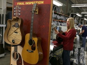 In this Friday, March 23, 2018 photo, a worker inspects a guitar at C. F. Martin and Co., in Nazareth, Pa. Guitar makers and other instrument makers are being hit hard by regulations aimed at preventing the world's rosewood species from disappearing. The international rules, which went into effect last year, regulated the trade in nearly 300 species of rosewood over concerns about widespread illegal logging in Asia and Africa. But guitar makers complain they are facing shipping delays and lost business from the new rules.