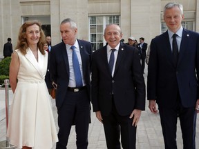 French Interior Minister Gerard Collomb, third left, Justice Minister Nicole Belloubet, left, French prosecutor in charge of terrorism Francois Molins, second left, and French Economy Minister Bruno Le Maire welcome international delegations for a conference to discuss ways to combat financing for the Islamic State group and Al-Qaida, at the OECD headquarters in Paris, Thursday, April 26, 2018. The initiative was launched by French President Emmanuel Macron to coordinate efforts to reduce the terror threat in the long term.