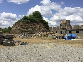 This undated photo, shows a large mound behind a motel in Franklin Township, Pa., that contains the Rhodes family cemetery. A group is suing the owners of a motel who started an excavation project in Pennsylvania that left their family cemetery a large mound of earth more than 25 feet high. The Observer-Reporter reports descendants of people buried in Rhodes Cemetery filed their lawsuit against Nikita Lodging Inc. April 4, 2018, saying they want the company to stabilize the cemetery, allow access to the area and restore the cemetery to its original condition.