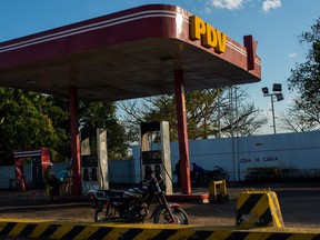 Residents sit at a closed Petroleos de Venezuela SA  gas station in Venezuela.