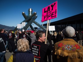 A man holds a sign as people gather for a rally in support of the Kinder Morgan Trans Mountain pipeline expansion in Vancouver, B.C., on Saturday March 10, 2018.