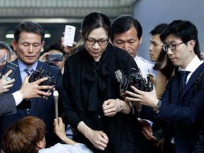 FILE - In this May 22, 2015 file photo, former Korean Air executive Cho Hyun-ah, center, is surrounded by reporters as she leaves the Seoul High Court in Seoul, South Korea. Korean Air Lines said Monday, April 23, 2018, that two daughters of its chairman will resign from their executive positions amid mounting public criticism over the women's behavior and the family's smuggling allegations.