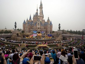 FILE - In this June 16, 2016 file photo, performers take to the stage during the opening ceremony for the Disney Resort in Shanghai, China. Walt Disney Co. is emphasizing its deep China connections as it launches an extension of Shanghai's $5.5 billion Disney Resort amid rising trade tensions between Washington and Beijing. Bob Weis, a top Disney executive, says most of the labor and materials that went into the new Toy Story Land are from China. "We're a local company," he said at the April 26, 2018 colorful launch. "Everything here is built and made in China."