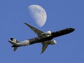 FILE - In this Aug. 23, 2015, file photo, an Air New Zealand passenger plane flies past the moon on its way to the Los Angeles International Airport from London, in Whittier, Calif. When a drone flew within meters of a landing passenger plane on March 25, 2018, Air New Zealand said reckless drone operators should be thrown in prison. Other agencies chimed in, calling such actions inexcusable and stupid. Yet The Associated Press has found that not one of them called police. Not while it was endangering the plane, nor later to try to track down the perpetrator.