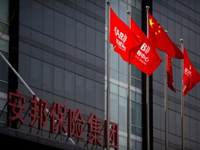 FILE - In this Feb. 23, 2018, file photo, Chinese and corporate flags fly in front of the offices of the Anbang Insurance Group in Beijing. The troubled Chinese insurer that owns New York City's Waldorf Hotel is receiving a $9.6 billion bailout from a government-run fund to shore up its finances. Anbang Insurance Group said Wednesday, April 4, 2018, the money from the China Insurance Security Fund would help it to "maintain stable operations."