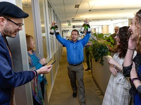FILE - In this April 10, 2017, file photo, the Salt Lake Tribune Editor Matt Canham breaks out the champagne after their 2017 Pulitzer Prize for local reporting was announced, in Salt Like City. The Tribune newsroom takes up one floor of the building that bears its name, overlooking snow-capped mountains and the arena where the Utah Jazz play. Once a Digital First property that dealt with staff reductions and feared closure, the paper was sold to a prominent local family in 2016. Since then, its reporters received their first raise in a decade and won a Pulitzer prize for investigative reporting.