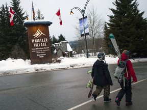 People pass a Whistler Village sign in Whistler, British Columbia, Canada, on Jan. 11, 2015. MUST CREDIT: David Ryder/Bloomberg