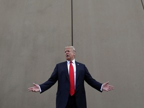 In this March 13, 2018 photo, President Donald Trump speaks during a tour as he reviews border wall prototypes in San Diego. Trump hails the start of his long-sought southern border wall, proudly tweeting photos of the "WALL!" Actually, no new work got underway. The photos show the continuation of an old project to replace two miles of existing barrier.