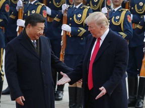 In this Nov. 9, 2017, photo, U.S. President Donald Trump, right, and Chinese President Xi Jinping gesture to each others during a welcome ceremony at the Great Hall of the People in Beijing. The brewing China-U.S. trade conflict features two leaders who've expressed friendship but are equally determined to pursue their nation's interests and their own political agendas. But while Trump faces continuing churn in his administration and a tough challenge in midterm congressional elections, Xi leads an outwardly stable authoritarian regime. Xi recently succeeded in pushing through a constitutional reform allowing him to rule for as long as he wishes while facing no serious electoral challenge.