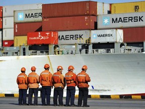 Chinese workers stand in front of a loaded cargo ship docked at a port in Qingdao in east China's Shandong province, Sunday, April 8, 2018. Amid falling markets, President Donald Trump's new economic adviser, Larry Kudlow, says there is no trade war between the U.S. and China. Another administration official, Treasury Secretary Steve Mnuchin, takes a different tack, saying he's "cautiously optimistic" that before any threatened tariffs go into place the two nations will reach an agreement. Global financial markets have fallen sharply as the world's two biggest economies square off. (Chinatopix via AP)