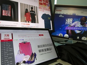 In this April 16, 2018, photo, computer screens display Alibaba's e-commerce website in Beijing, China. Executives tell AP their companies were punished by Alibaba after they refused to enter exclusive partnerships with the Chinese e-commerce giant. Traffic to their Tmall storefronts fell, hurting sales, as they fought for fair access to a $610 billion Chinese online marketplace. Alibaba says it offers perks for exclusivity but has never punished anyone.
