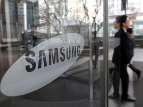 FILE - In this Jan. 31, 2018 file photo, an employee walks past a logo of the Samsung Electronics Co. at its office in Seoul, South Korea. Samsung Electronics says its first-quarter operating profit likely jumped 56 percent to a record high. The South Korean tech giant estimated in its preliminary earnings report Friday, April 6, 2018, that its January-March operating income was 15.6 trillion won ($14.7 billion), compared with 9.9 trillion won a year earlier. The estimate was higher than expected.