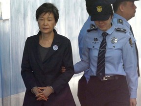 FILE - In this Oct. 10, 2017, file photo, former South Korean President Park Geun-hye, left, arrives to attend a hearing on the extension of her detention at the Seoul Central District Court in Seoul, South Korea. A South Korea court is set to issue a verdict Friday, April 6, 2018, on disgraced former President Park over a corruption scandal. Park has been held at a detention center near Seoul since her arrest in March 2017, after she was removed from office on a landmark court ruling. Prosecutors have requested a 30-year prison term on her.