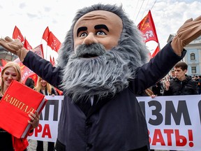 demonstrator dressed as Karl Marx marches along with activists and supporters of Russia's left-wing parties and movements during a May Day rally in Moscow on May 1, 2018.