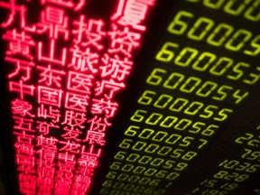 Stock price movements are seen on a screen at a securities company in Beijing on March 23, 2018.