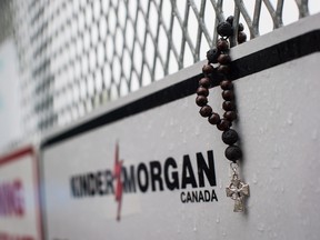 Rosary beads are seen on a gate at Kinder Morgan's facility in Burnaby, B.C., as religious leaders and more than 100 members of diverse faith communities participate in a protest against the company's expansion of the Trans Mountain pipeline, on Saturday April 28, 2018.