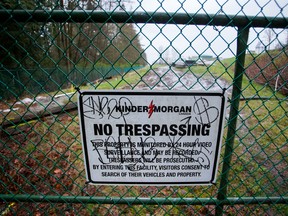 A "No Trespassing" sign is displayed on a fence outside of the Kinder Morgan Inc. facility in Burnaby, British Columbia.