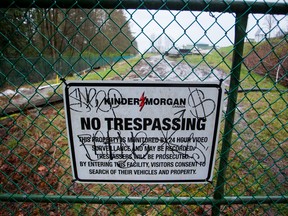 A "No Trespassing" sign is displayed on a fence outside of the Kinder Morgan Inc. facility in Burnaby, British Columbia. Cleanup is underway for a crude oil spill at a Kinder Morgan station north of Kamloops, B.C.