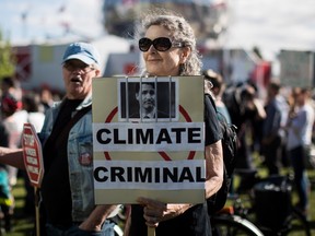 Donna Oleksiuk holds a sign bearing a photograph of Prime Minister Justin Trudeau, during a protest against the Kinder Morgan Trans Mountain Pipeline expansion in Vancouver on Tuesday May 29, 2018.