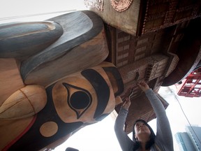 Jocelyn Campbell-Axson, of the Musqueam First Nation, hammers a copper nail into the Reconciliation Pole before its raising at the University of British Columbia in Vancouver in 2017. The 17-metre pole tells the story of the time before, during and after the Indian residential school system. The copper nails represent thousands of Indigenous children who died in the  schools.