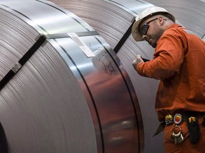 A worker inspects coiled steel at Dofasco in Hamilton, Ont.